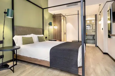 a bedroom with a large bed and a small table at Hotel Orangine in Hospitalet de Llobregat