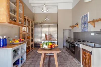 a kitchen with a table with a bowl of fruit on it at Masia Victoria in Sant Pere de Ribes