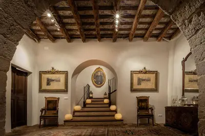 a room with a staircase in a building with two chairs at Masia Victoria in Sant Pere de Ribes