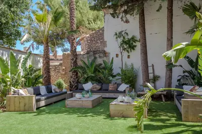 a backyard with a couch and trees and grass at Masia Victoria in Sant Pere de Ribes