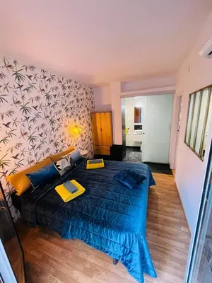 a bedroom with a large bed with two yellow folders on it at Stunning 2 bedroom Apartment with great design Sitges centre beach in Sitges