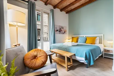a bedroom with a bed and a table and a couch at Lodging Apartments Barceloneta Beach Studio 12 in Barcelona