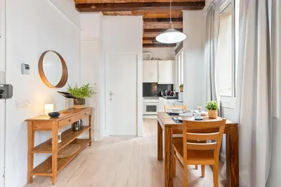 a kitchen and dining room with a wooden table and chairs at Lodging Apartments Barceloneta Beach Studio 12 in Barcelona