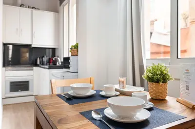 a kitchen with a wooden table with dishes on it at Lodging Apartments Barceloneta Beach Studio 12 in Barcelona
