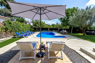 a patio with chairs and an umbrella and a pool at Catalunya Casas Stunning Villa with private pool 33 km to Barcelona in Senmanat