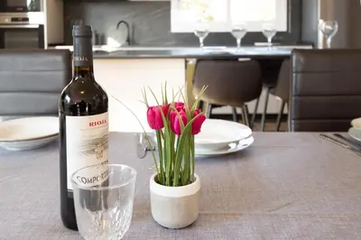 a bottle of wine sitting on a table with flowers at Catalunya Casas Stunning Villa with private pool 33 km to Barcelona in Senmanat