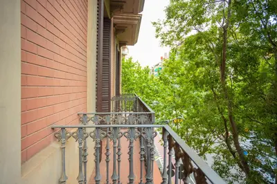 a balcony of a house with trees in the background at ApartEasy - Casanova Elegance in Barcelona