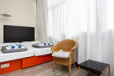 a small bedroom with a bed and a chair at ApartEasy - Casanova Elegance in Barcelona