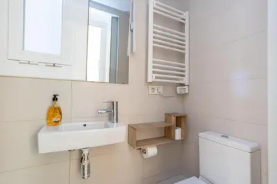 a white bathroom with a sink and a toilet at ApartEasy - Casanova Elegance in Barcelona