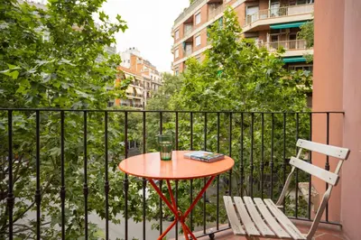 a small table and a chair on a balcony at ApartEasy - Casanova Elegance in Barcelona