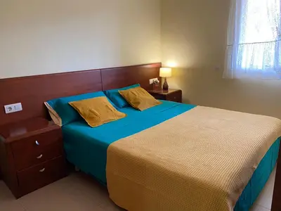 a bedroom with a bed with blue sheets and gold pillows at Sitges Living Apartment in Sitges