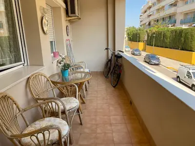 a balcony with chairs and a table and a bike at Sitges Living Apartment in Sitges