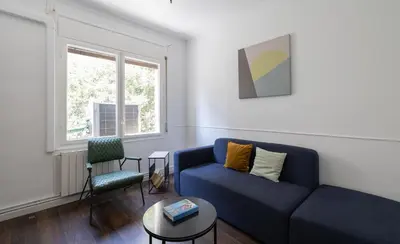 a living room with a blue couch and a chair at Stay U-nique Apartments Estación del Norte in Barcelona