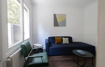 a living room with a blue couch and a window at Stay U-nique Apartments Estación del Norte in Barcelona