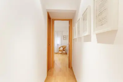 a hallway with white walls and a wooden floor at Stay U-nique Apartments Terrassa in Barcelona