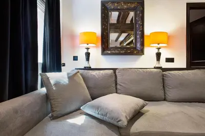 a couch in a living room with a mirror and lamps at Stay U-nique Apartments Carretes in Barcelona