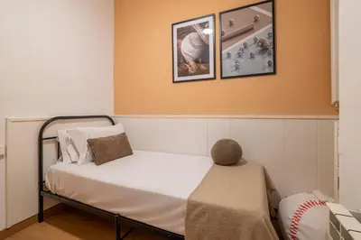 a small bedroom with a bed and a chair at Stay U-nique Apartments Sant Antoni in Barcelona