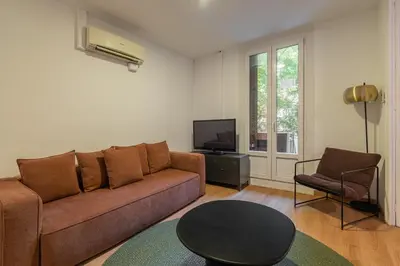 a living room with a couch and a table and a tv at Stay U-nique Apartments Sant Antoni in Barcelona