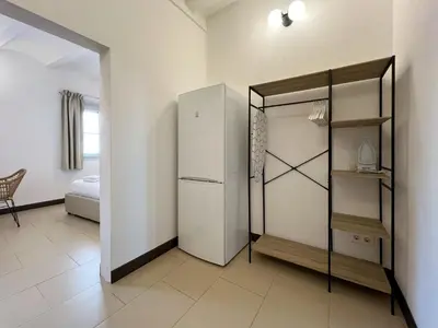 a kitchen with a refrigerator and a room with a bed at Stay U-nique Apartments Pasteur in Barcelona