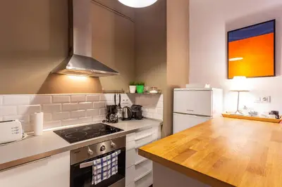 a kitchen with a stove top oven next to a refrigerator at Stay U-nique Apartments Parlament in Barcelona