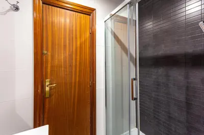 a bathroom with a shower and a wooden door at Stay U-nique Apartments Parlament in Barcelona