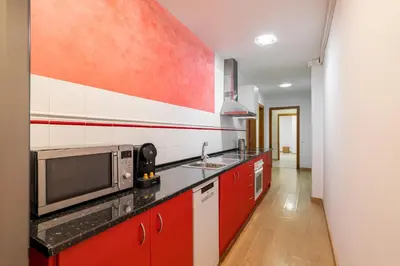 a kitchen with red cabinets and a microwave at Stay U-nique Apartments Passatge de Font in Barcelona