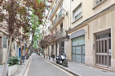 a motorcycle parked on a street next to buildings at Stay U-nique Apartments Passatge de Font in Barcelona