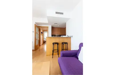 a kitchen and a living room with a purple couch at Stay U-nique Apartments Industria in Barcelona