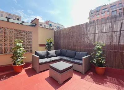 a patio with a couch and plants on a balcony at Stay U-nique Apartments Rocafort in Barcelona