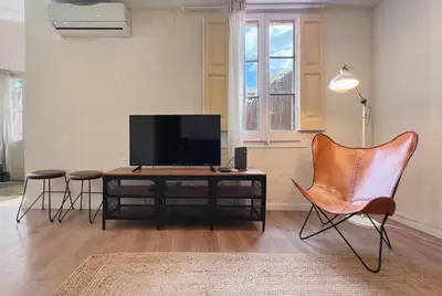 a living room with a television and two chairs at Stay U-nique Apartments Rocafort in Barcelona
