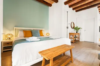 a bedroom with a large bed with a wooden table at Lodging Apartments Barceloneta Beach Studio P2 in Barcelona
