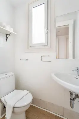 a white bathroom with a toilet and a sink at The Collection Barcelona - Paseo de Gracia 5BD and 3BTH for 10 with Terrace in Barcelona