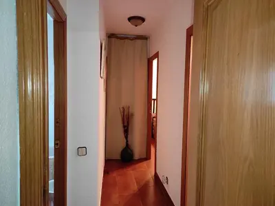 a hallway with a vase in the middle of a room at a18' de Barcelona y 10' de circuito de Cataluña in Barcelona