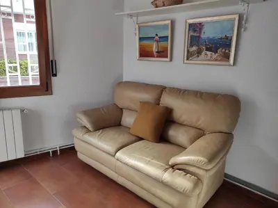 a brown leather couch in a living room at a18' de Barcelona y 10' de circuito de Cataluña in Barcelona