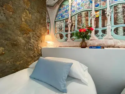 a white couch with a blue pillow and a window at The Yellow House by MyRentalHost in Barcelona