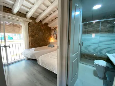 a bedroom with two beds and a glass door at The Yellow House by MyRentalHost in Barcelona