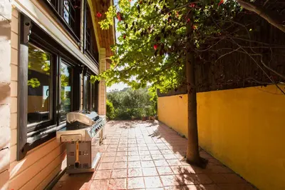 an empty sidewalk next to a building with a tree at Finland House Barcelona- Ideal familias in Argentona