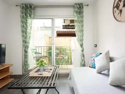 a living room with a couch and a table and a window at Matarolux20 in Mataró