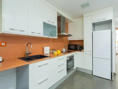a white kitchen with white cabinets and a sink at Matarolux20 in Mataró