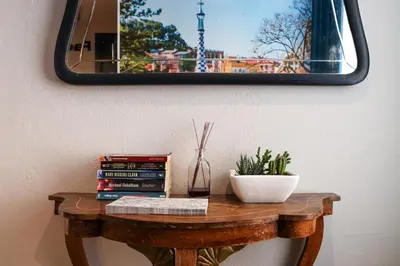 a table with books and a mirror on a wall at Factory Hostels Barcelona in Barcelona
