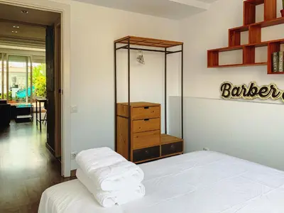 a bedroom with a bed and a dresser with towels at Incredible 2BR Penthouse with Urban Rooftop Garden in Barcelona