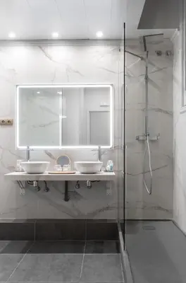 a bathroom with two sinks and a mirror and a shower at La Maison de Barcelone in Barcelona