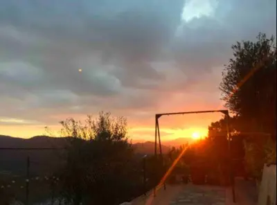 a sunset with the sun setting in the sky at La Bruixa Rural in Dosríus