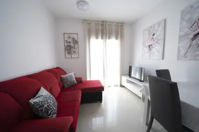 a living room with a red couch and a television at Apartamento centro histórico en Manresa in Manresa