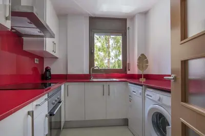 a red kitchen with a sink and a washing machine at Apartamento centro histórico en Manresa in Manresa