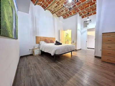 a bedroom with a large bed in a room at Apartahotel Casa Batito in Hospitalet de Llobregat