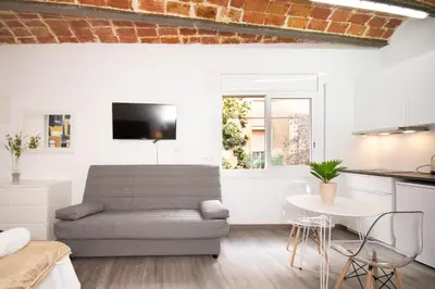 a living room with a couch and a table at Apartahotel Casa Batito in Hospitalet de Llobregat