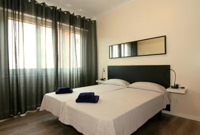 a bedroom with a large bed with two blue towels on it at ClassBedroom Gaudí Apartments in Barcelona