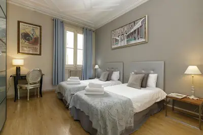 a bedroom with two beds and a desk and a chair at Enjoy Apartments Gran Via in Barcelona