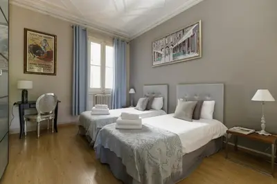 a bedroom with two beds and a desk and a chair at Enjoy Apartments Gran Via in Barcelona